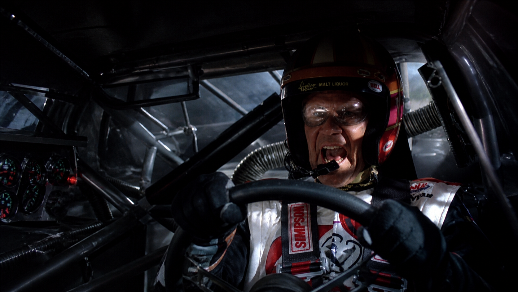 Talladega Nights film still with a racing driver at the wheel.