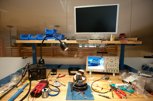 Electronics and speaker components on a studio workbench during prototype development.