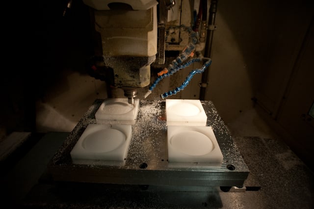 Prototype components under a CNC milling machine in the workshop.