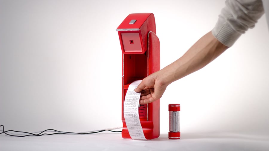 A receipt machine printing out a long receipt with a grocery list on it.