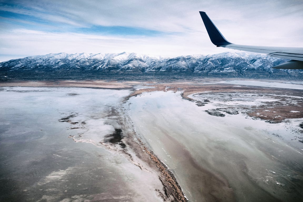 An airplane window above snow-covered terrain, December 2016.
