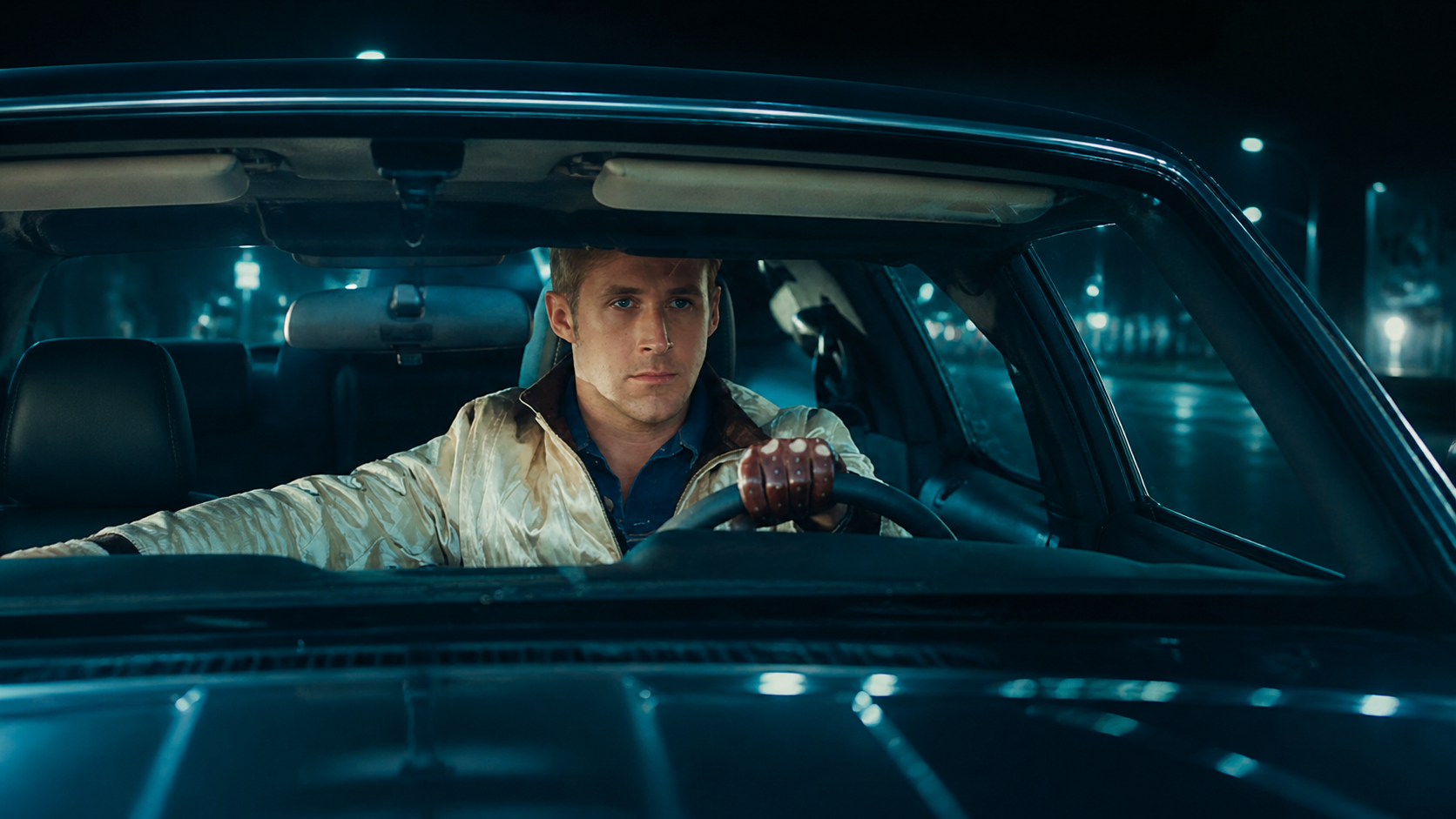 Drive film still with a serious driver inside a car.