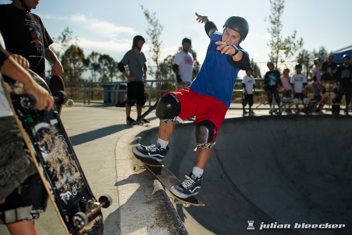 Christian Hosoi performing a Smith grind on a concrete pool wall.