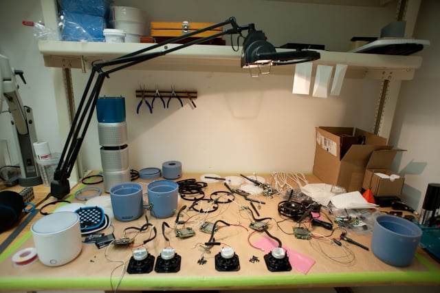 Studio workbench with early Social Speaker parts, tools, and materials.