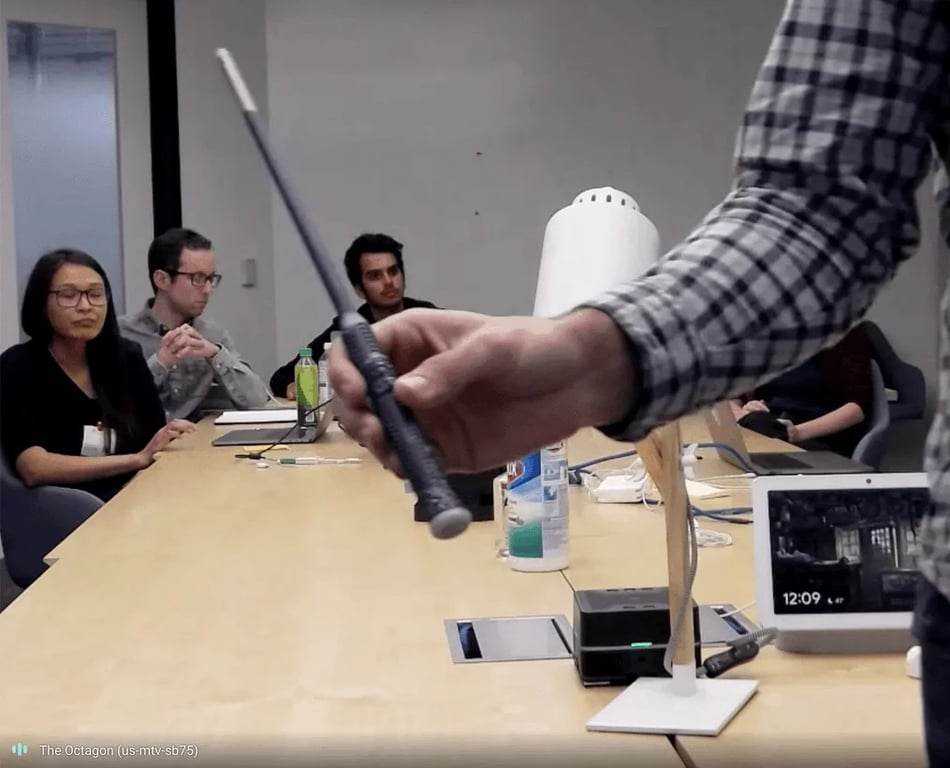 A black wand is held in front of Project Elder prototype hardware during a product-test session.