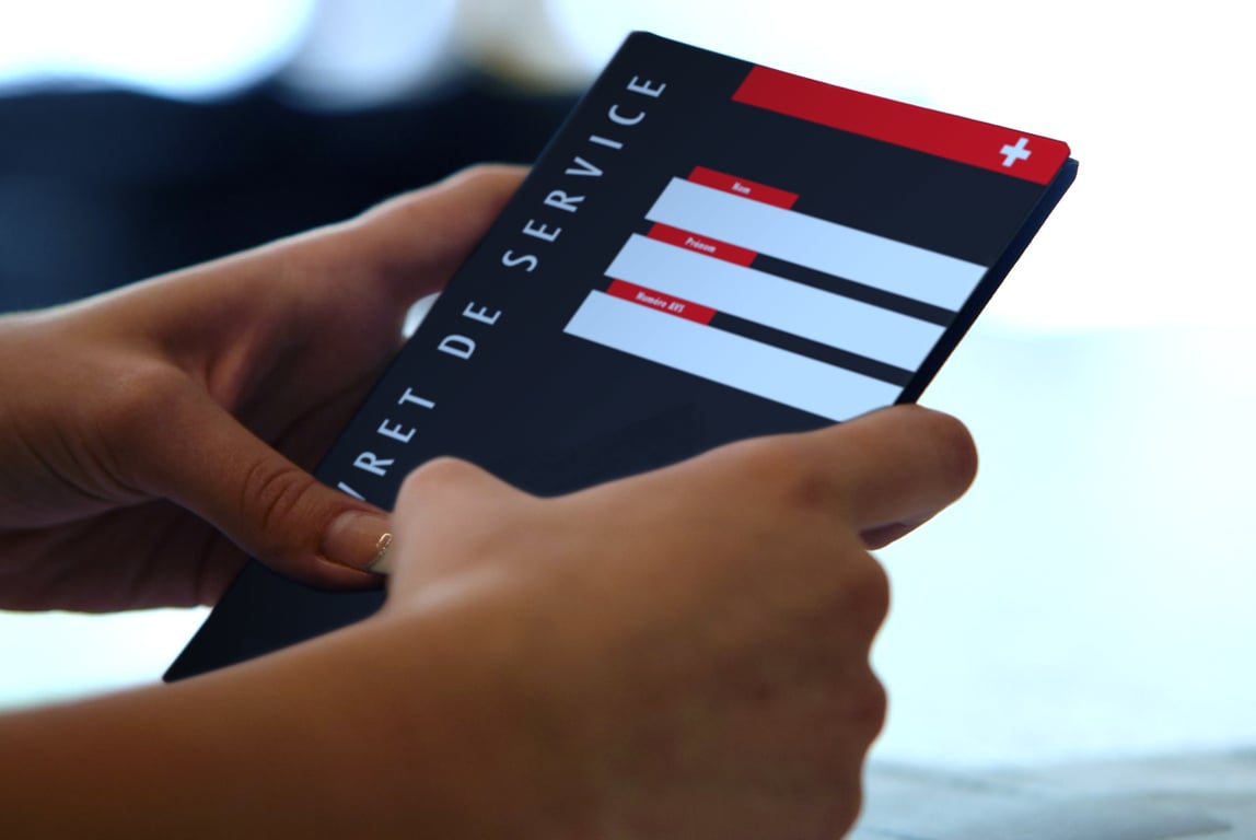 Hands holding the black Swiss service booklet with a red band, white cross, and blank personal-information fields.