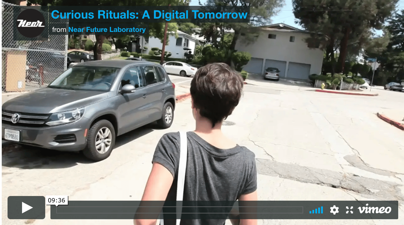 A Vimeo player screenshot for Curious Rituals: A Digital Tomorrow, showing a person walking along a residential street.