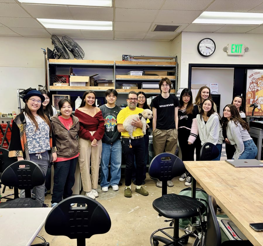 Students and professor standing in a row in a studio space