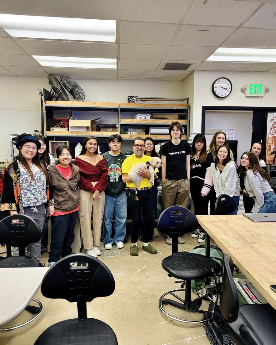 Students and professor standing in a row in a studio space