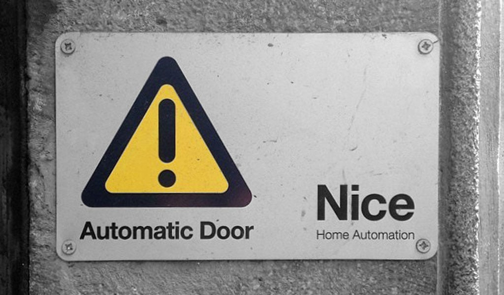 A weathered Automatic Door warning sign beside the Nice Home Automation logo.