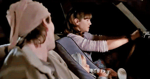 Animated film still from Raising Arizona showing Ed driving with H.I. seated beside her in a car.