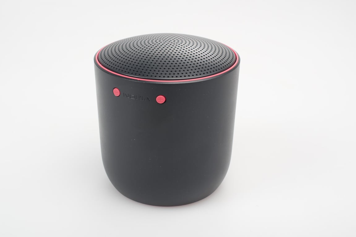 Black Social Speaker form prototype against a pale background, front controls illuminated red.