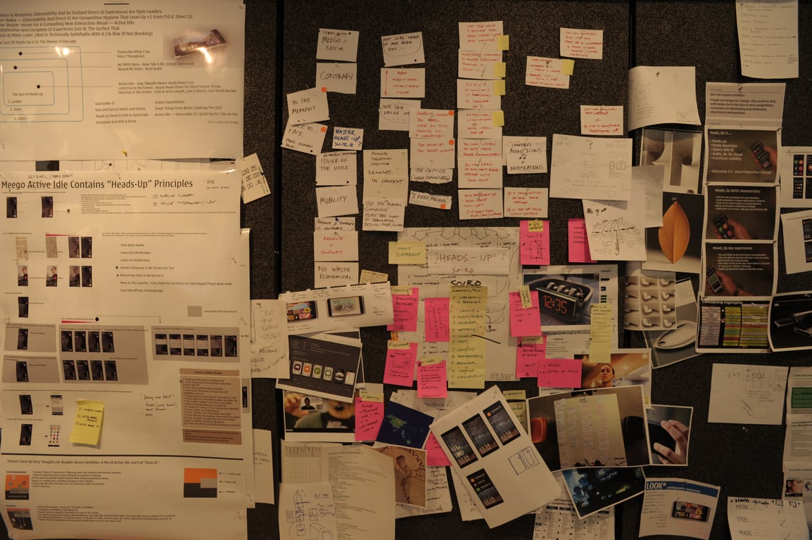 A full wall of printed mobile interface screens, diagrams, and notes from the Heads Up project.