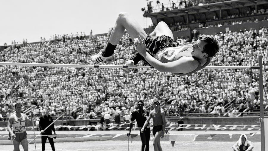 Dick Fosbury going over the high bar backwards,