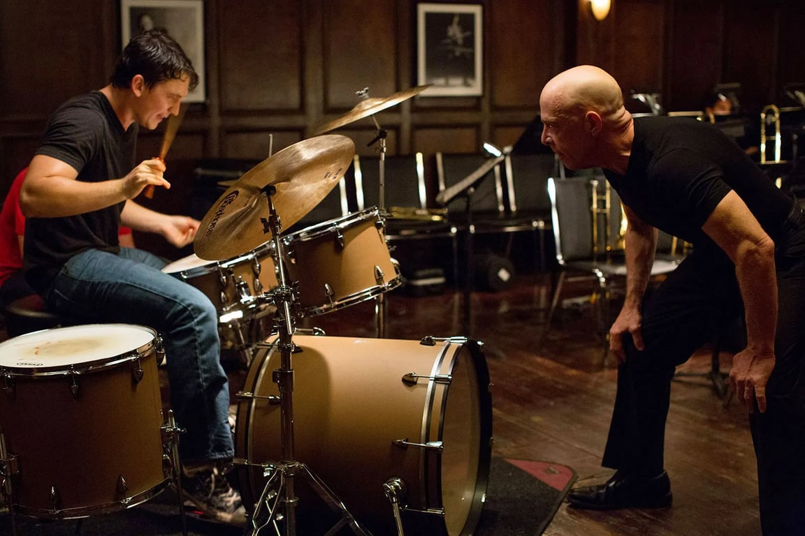 A scene from the film Whiplash with a drummer and band instructor in tense poses