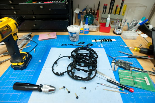 Social Speaker electronic components and tools arranged on a blue work mat.