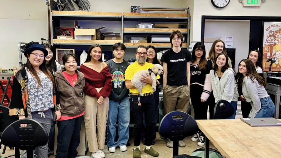Students and professor standing in a row in a studio space