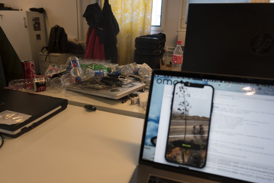 The app in the simulator amid laptops, cables and empty bottles.