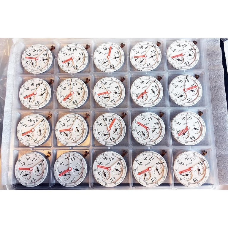 A tray holding twenty white Omata One watch dials in individual clear cases.