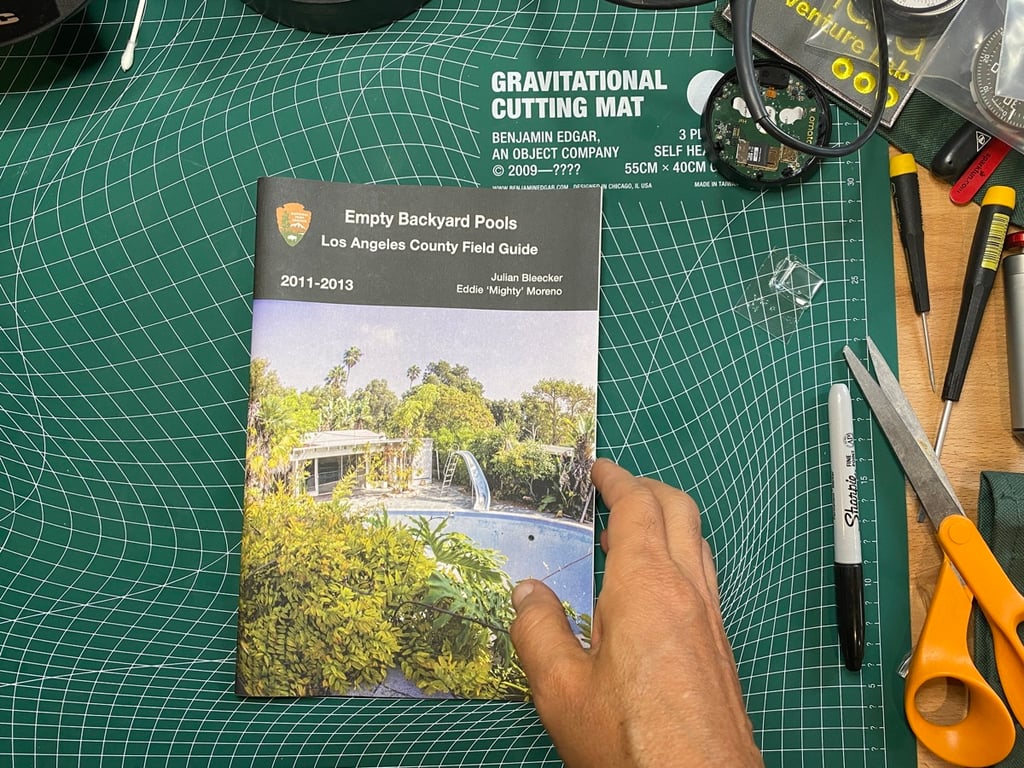 The finished Empty Backyard Pools field guide on a green studio cutting mat.