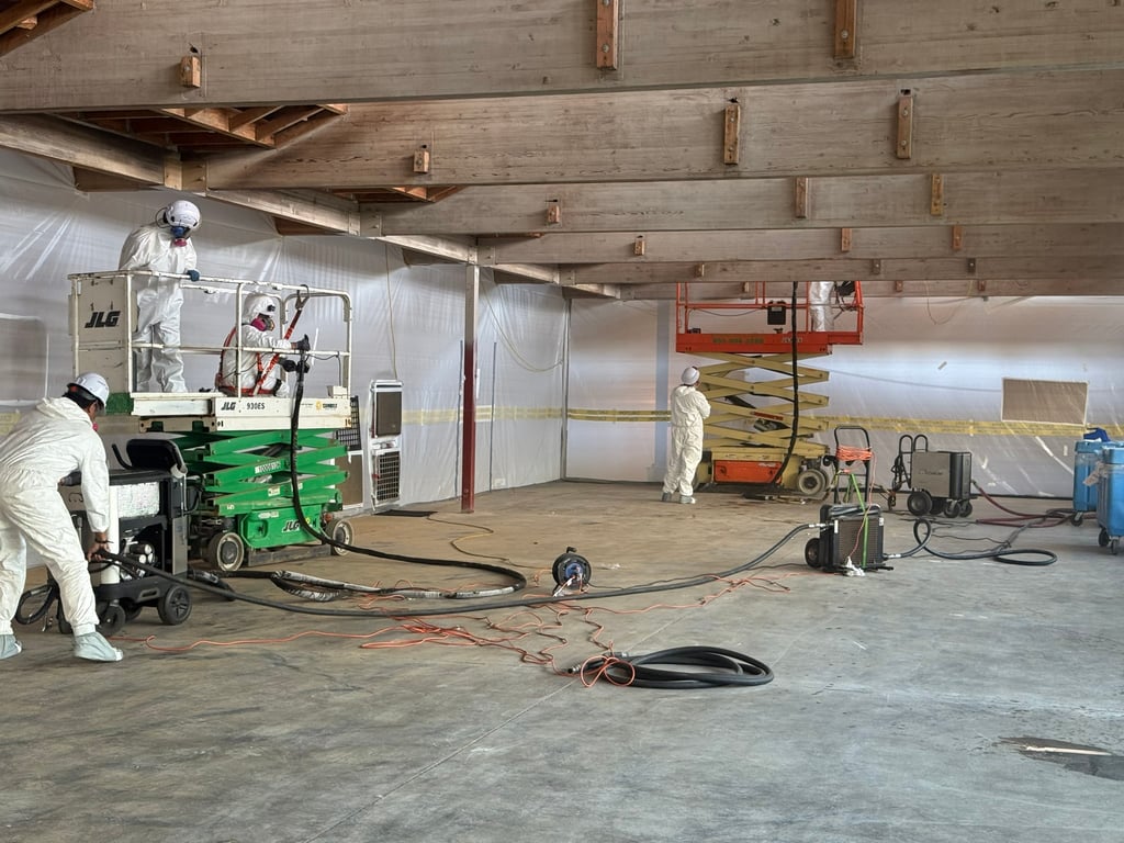 Fully equipped Ice Blast Works crew in PPE working from scissor lifts on an elevated exterior surface