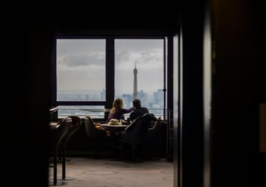A couple dining at a restaurant overlooking the Eiffel tower in Paris, France.