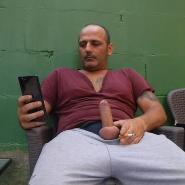 A thick, juicy cock extending from a muscled dude enjoying a smoke, check out this pic.