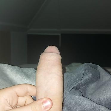 This 17cm thick white cock shows off its bushy pubic hair in this close-up photo.