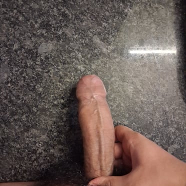 A thick, veiny cock with bushy pubic hair, a beautiful dick pic.