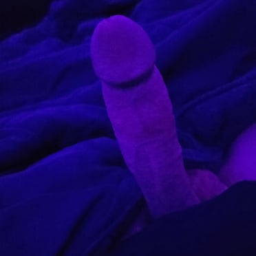 A beautiful, thick cock with prominent veins, presented in a purple-lit photo.