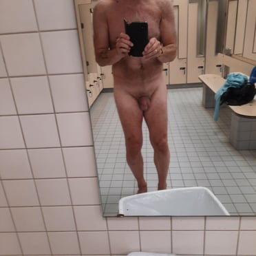 A thick, veiny cock with prominent balls and light pubic hair, captured in this locker room pic.