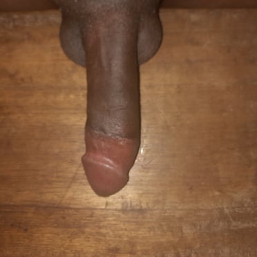A beautiful, thick, dark-skinned dick with prominent balls, perfect for a muscled stud.