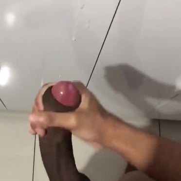 A big, juicy black cock with prominent balls, photographed by a muscled stud.