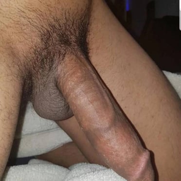 This pic shows a thick, veiny, uncut, dark-skinned dick, hanging over the balls and is going to destroy you.
