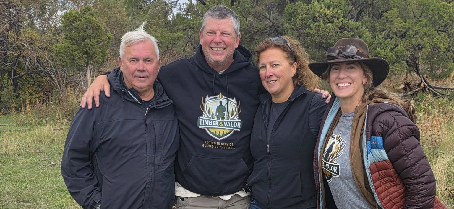 Four people together outdoors at camp