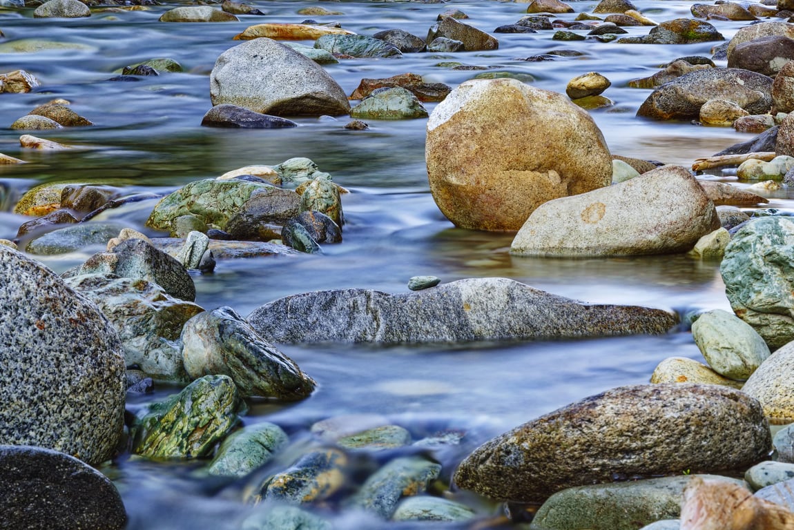 Clear water over colorful river rocks