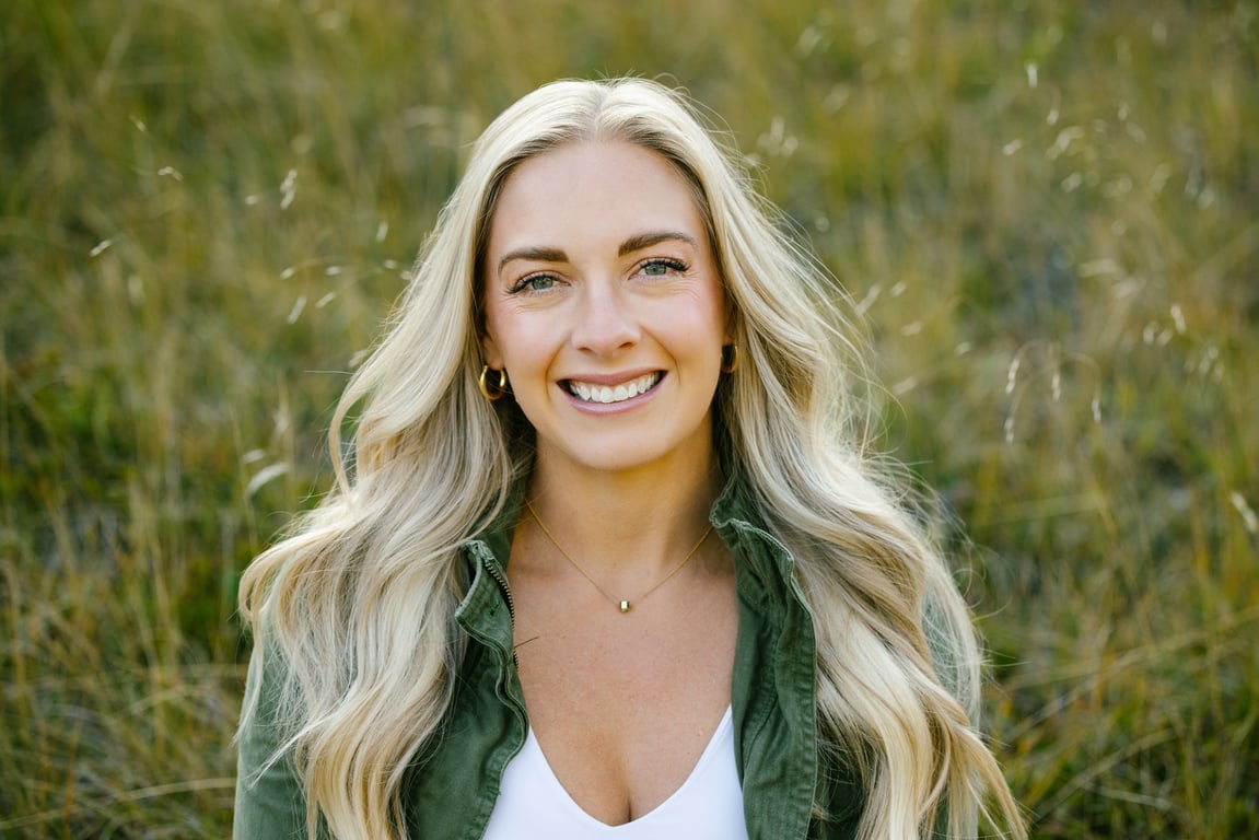 Hannah Bruha, broker with Clearwater Properties, in a green jacket in tall Montana grass