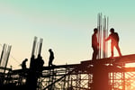 Silhouette of construction workers on scaffolding