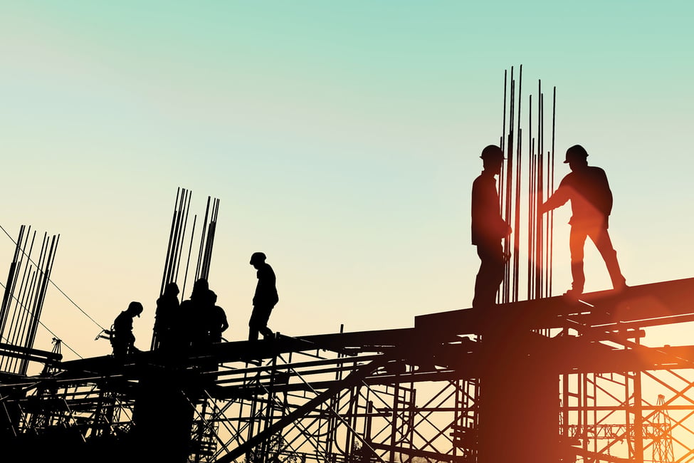 Silhouette of construction workers on scaffolding
