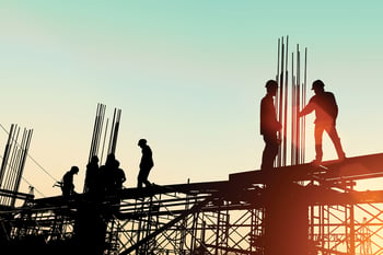 Silhouette of construction workers on scaffolding