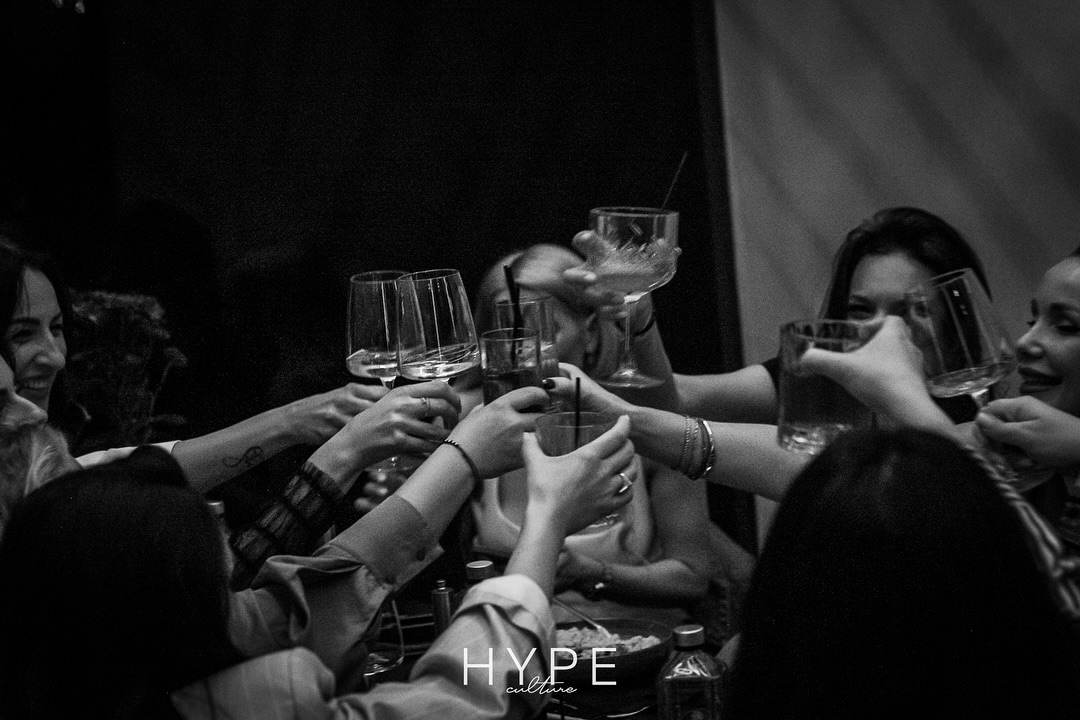 Group of people toasting with drinks in black and white