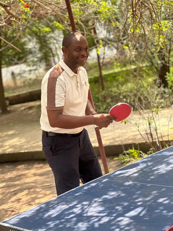A church member enjoying a game of table tennis in the shade