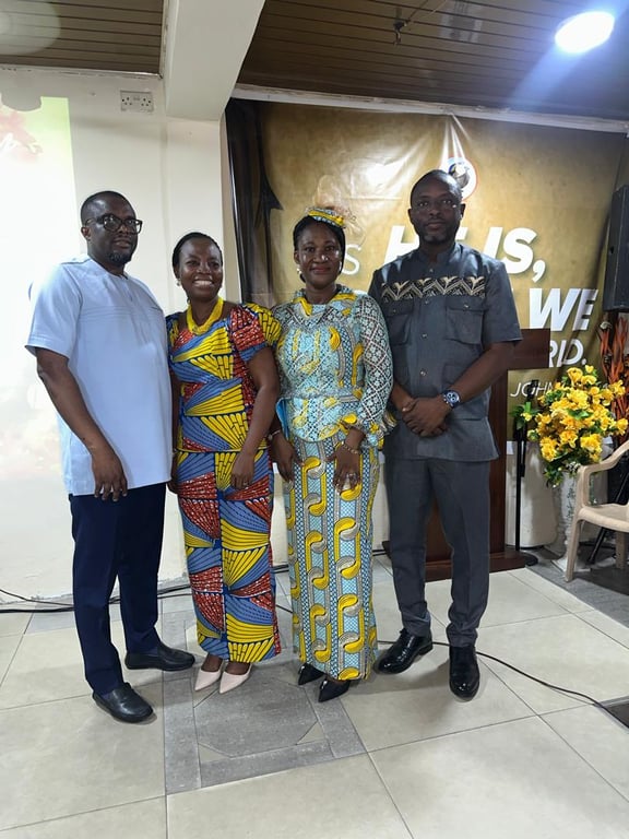 Two couples posing together in front of the church banner on Mother’s Day