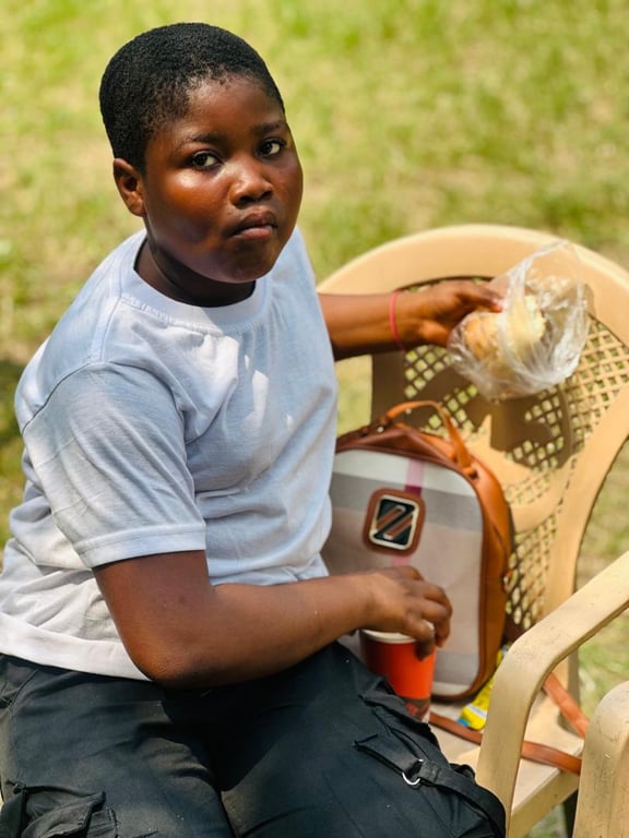 A child seated with a snack and a drink at the Love Feast
