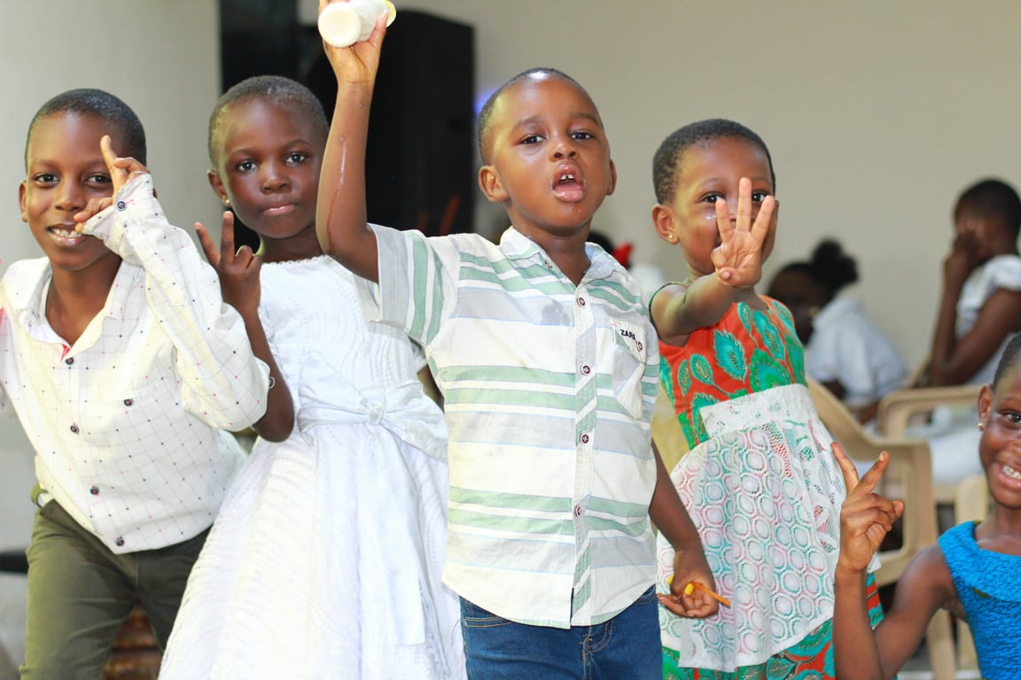 Children standing together and raising their hands during a ministry gathering