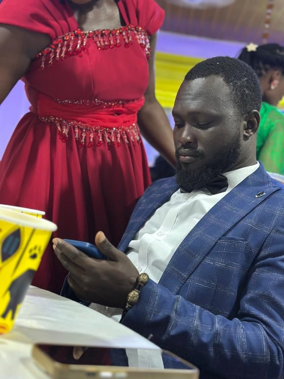 A man in a blue suit and bow tie seated at a table during Counselling 101