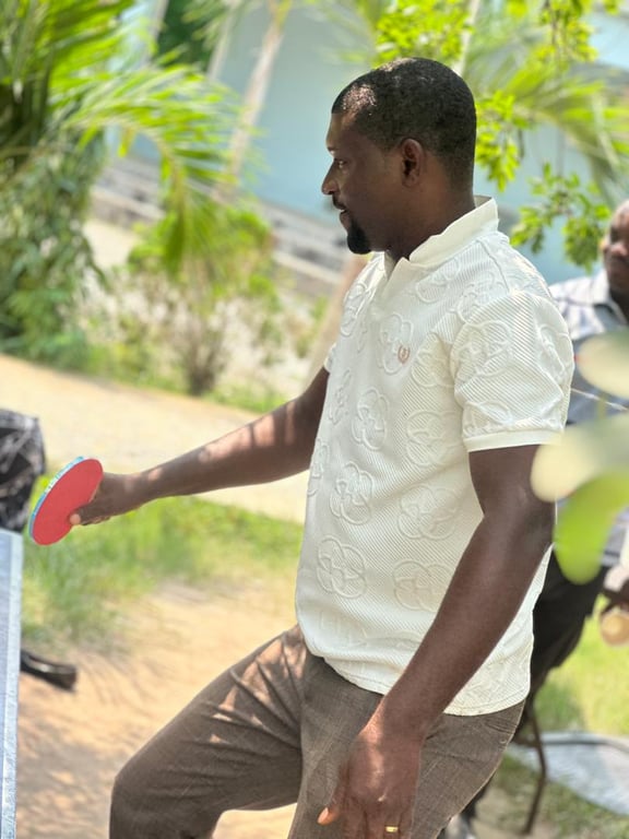 A church member in a white shirt playing table tennis