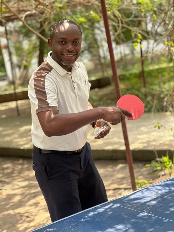 A smiling church member holding a table tennis bat