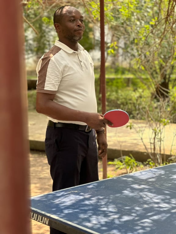A church member playing table tennis outdoors during a fellowship outing