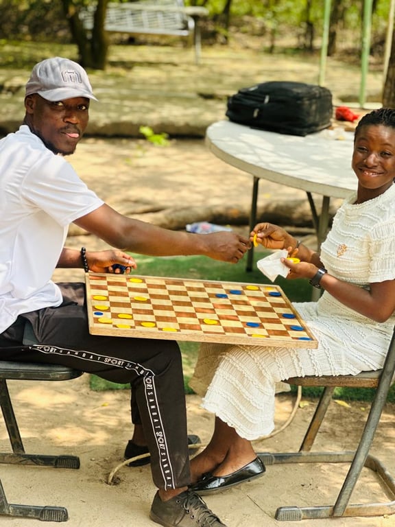 Two church members playing a game of draughts outdoors at the Love Feast
